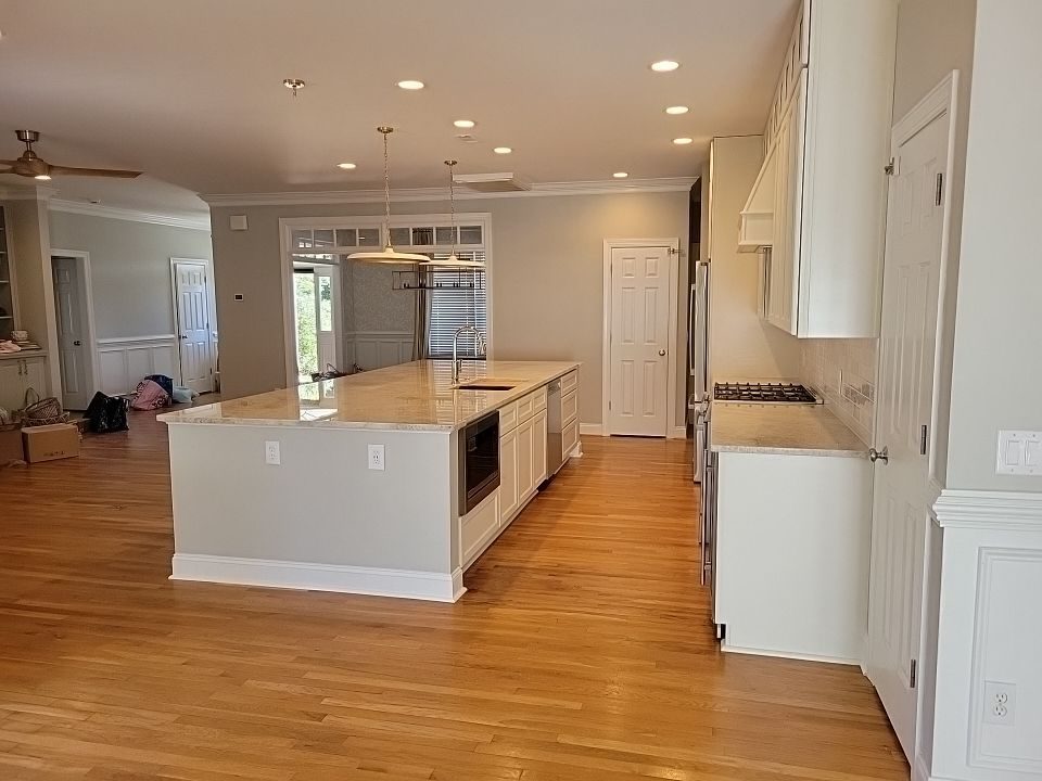 An open kitchen with a long island and wood floors