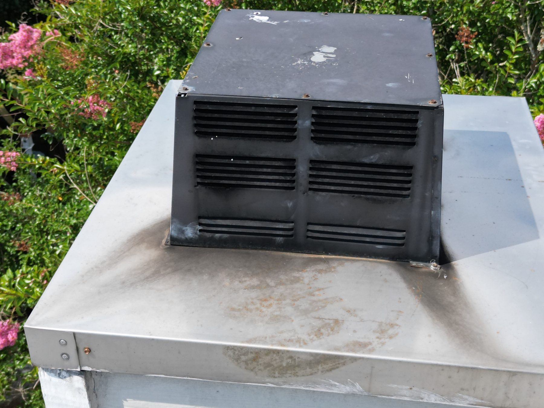 Metal chimney chase cover and cap seen from above