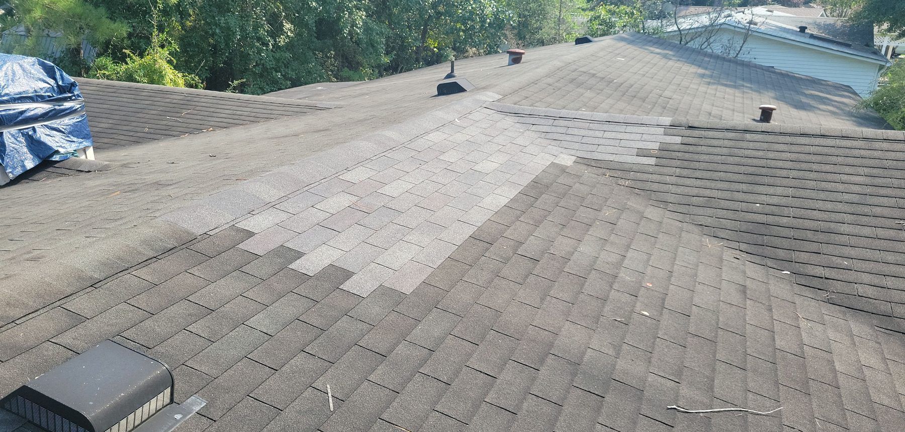 A patch of newer shingles repaired on an older roof