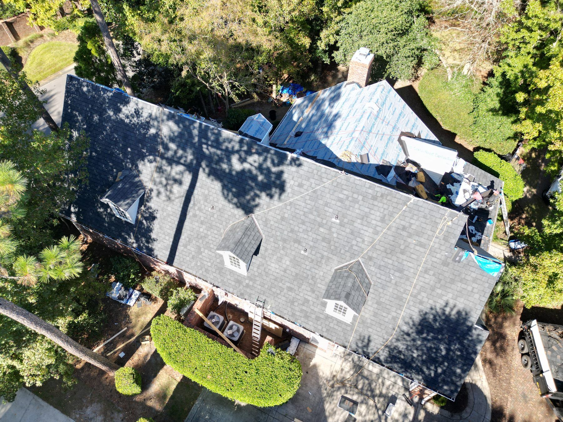 New dark shingles going on over the underlayment, partly done