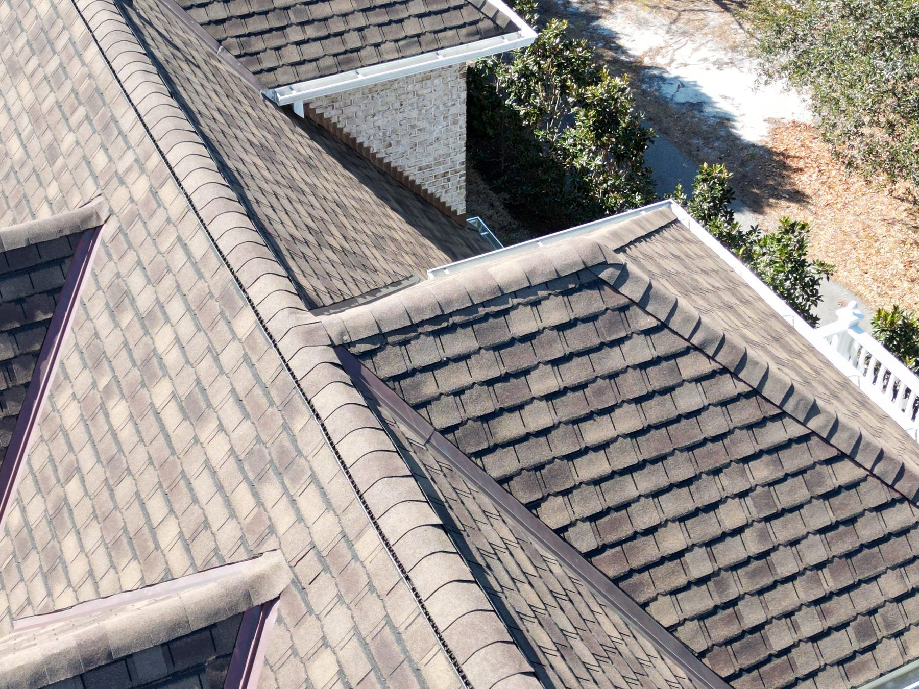 Architectural shingles meeting dormers, close aerial view