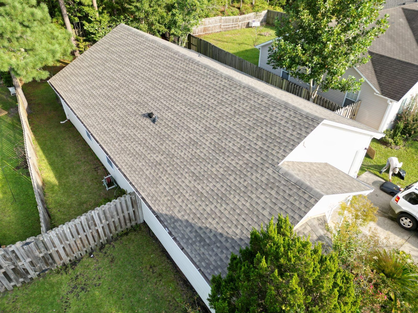 Gray shingle roof beside a fenced yard