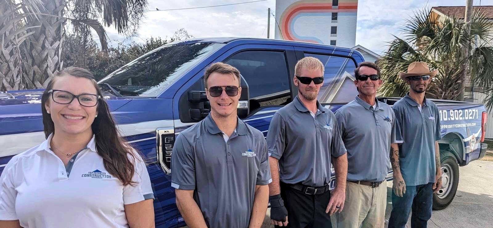 TPC team members standing in front of the blue TPC truck